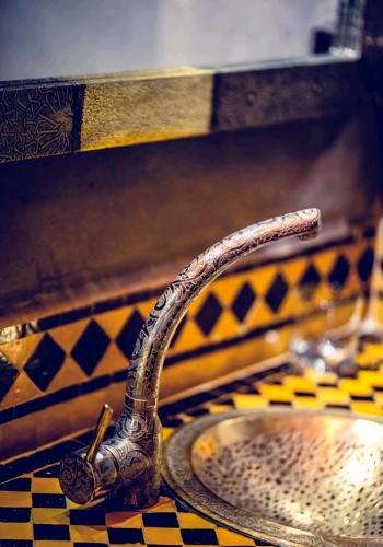 a bathroom sink with a snake shapedaucet on a counter at La Perle de l'Atlas by Golf Resort in Marrakesh