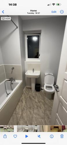 La salle de bains est pourvue d'un lavabo, de toilettes et d'une fenêtre. dans l'établissement Coxwell, à Mill Hill