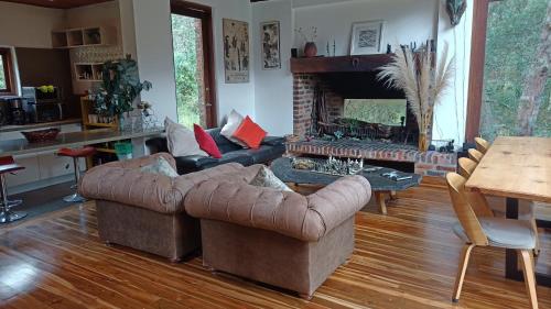 sala de estar con sofá y chimenea en Casa Libelula en El Chuscal