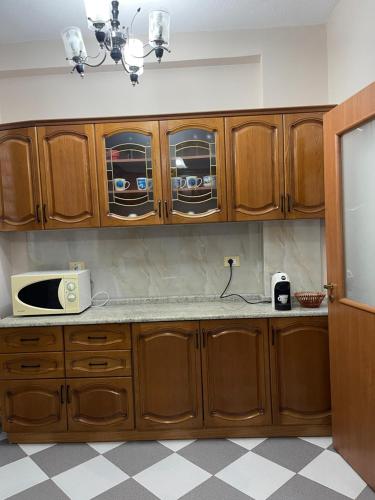 a kitchen with wooden cabinets and a microwave at LuxurySeaview Apartment in Durrës