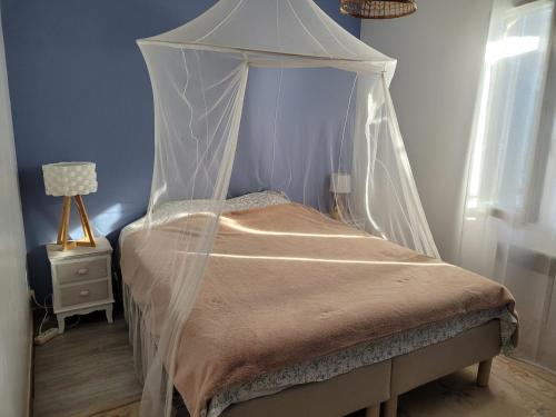 un lit à baldaquin dans une chambre dans l'établissement Villa piscine, à Marseillan