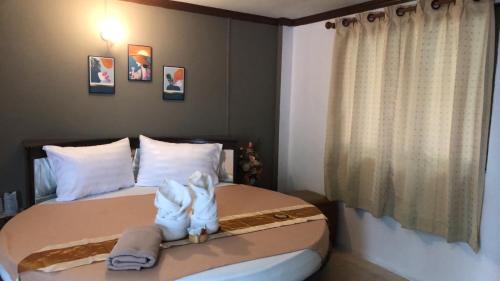 ein Schlafzimmer mit einem Bett mit zwei Handtüchern darauf in der Unterkunft ทุ่งทองรีสอร์ท in Ban Khlong Toei (1)