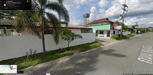an empty street with a palm tree next to a building at ทุ่งทองรีสอร์ท in Ban Khlong Toei (1)