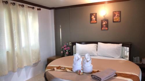 ein Schlafzimmer mit einem Bett mit zwei Handtüchern darauf in der Unterkunft ทุ่งทองรีสอร์ท in Ban Khlong Toei (1)