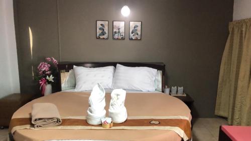 ein Schlafzimmer mit einem Bett mit weißen Stiefeln darauf in der Unterkunft ทุ่งทองรีสอร์ท in Ban Khlong Toei (1)