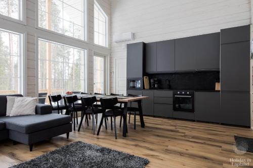 een keuken met een tafel en stoelen en een bank bij Holiday in Lapland - Villa Lapintuuli in Kittilä
