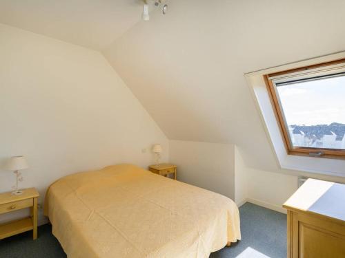 een kleine slaapkamer met een bed en een raam bij Appartement Carnac, 3 pièces, 6 personnes - FR-1-477-63 in Carnac