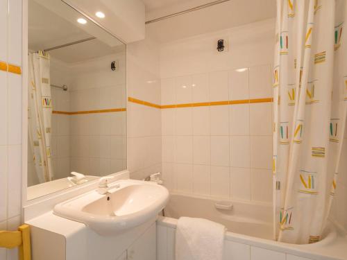 een witte badkamer met een wastafel en een bad bij Appartement Carnac, 3 pièces, 6 personnes - FR-1-477-63 in Carnac