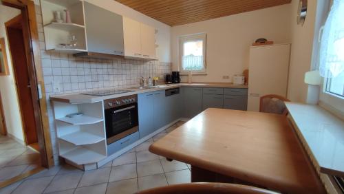 a kitchen with a stove and a wooden table at Ferienwohnung Familie Haas in Gößweinstein