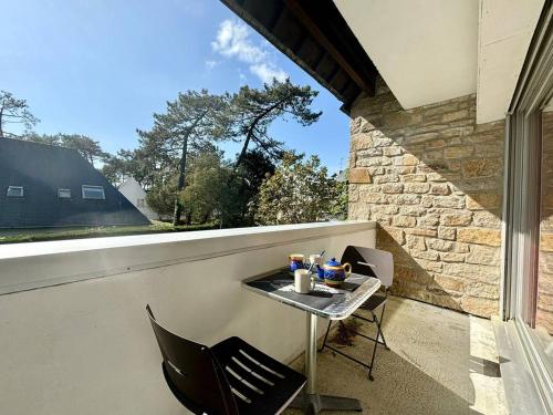 d'une petite table et de chaises sur un balcon avec fenêtre. dans l'établissement Appartement T2 + Cabine à Carnac, Proche Plages, Balcon, Parking, 4 Pers. - FR-1-377-51, à Carnac