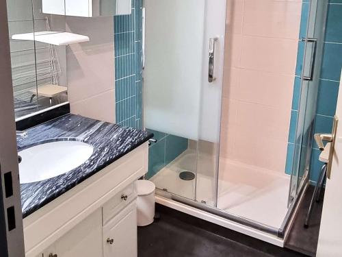 une salle de bain avec un lavabo et une douche en verre dans l'établissement Charmant T2 Cabine Climatisé, Piscine, Parking, à 30m de la Mer, pour 5 Pers, Terrasse Orientée Sud - FR-1-607-100, au Cap d'Agde