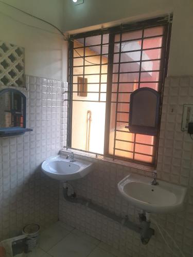 a bathroom with two sinks and a window at UK YATHRINIVAS in Udupi