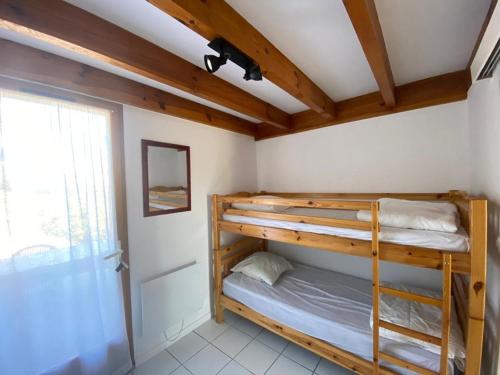 une chambre avec deux lits superposés et une fenêtre dans l'établissement Villa Patio Accès Direct Océan, Terrasse, Parking, Piscine, 2 Chambres + Mezzanine - FR-1-413-163, à Capbreton