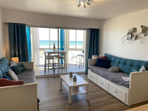 un salon avec un canapé et une table dans l'établissement Appartement T2 face à l'océan avec terrasse fermée - 4 pers, Vieux-Boucau-les-Bains - FR-1-379-143, à Vieux-Boucau-les-Bains