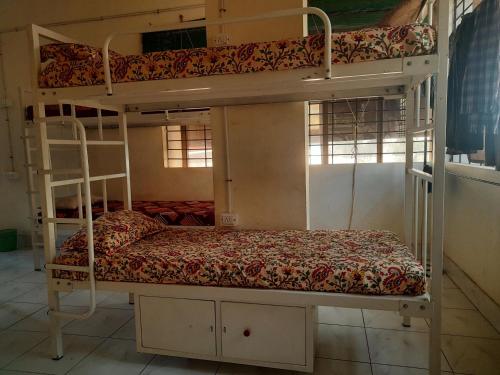 a bedroom with two bunk beds in a room at UK YATHRINIVAS in Udupi