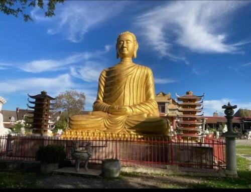 uma grande estátua de Buda dourado num parque em Un chalet suspendu au paradis sur un domaine de 20 hectares em Cressanges