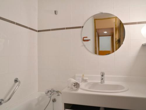 a white bathroom with a sink and a mirror at Studio Plagne Bellecôte, 1 pièce, 4 personnes - FR-1-181-2333 in La Plagne Tarentaise