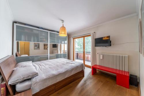 a bedroom with a large bed and a red bench at Chesa Sonnalpine B - St. Moritz in St. Moritz