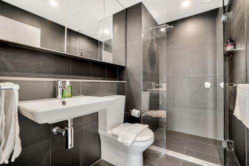 uma casa de banho com um lavatório, um WC e um chuveiro em Stunning 3B2B1C high-rise with a water frontage 1 em Melbourne