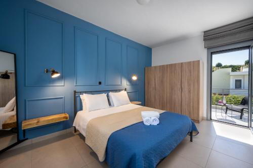 a blue bedroom with a bed with a blue wall at Wonderview Exclusive Apartment in Kremasti