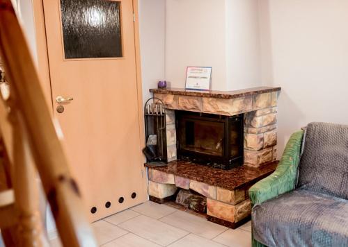 a living room with a stone fireplace next to a door at Apartament EmKa z tarasem Rowy in Rowy