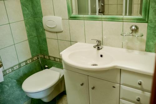 a bathroom with a white sink and a toilet at Apartament EmKa z tarasem Rowy in Rowy