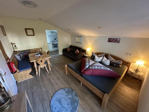 Sala de estar con cama, sofá y mesa en Haus Alpenruh en Biberwier