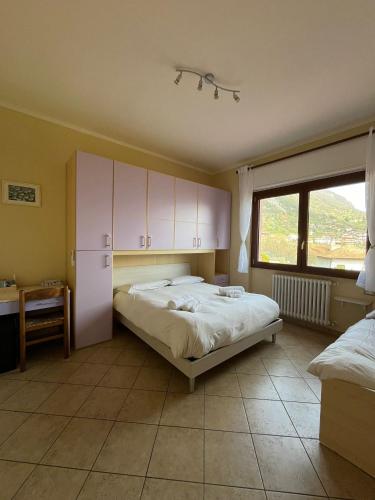 a bedroom with a bed with white cabinets and a window at B&B Garzola in Ossuccio