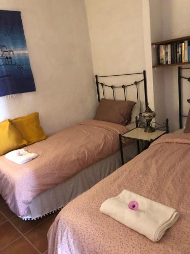 a room with two beds with a towel on the bed at Cortijo el Abejaruco in Almuñécar