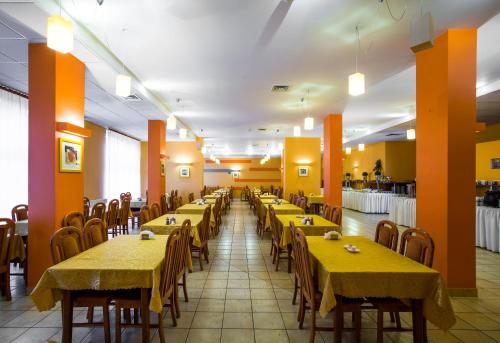 a dining room with yellow tables and chairs at Hotel *** NAT Kołobrzeg in Kołobrzeg