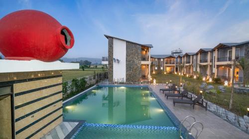 a pool at a resort with a large red ball on top of it at The Forest By 3Tree Group in Rāmnagar