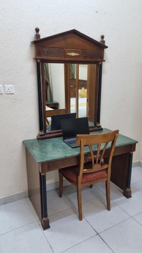 a wooden desk with a mirror and a chair at Welcom medina in Al ‘Awālī