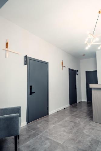 an empty room with two doors and a chair at Green Hill in Almaty