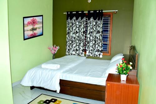 1 dormitorio con cama y ventana en Royal Guest House en Chikmagalūr
