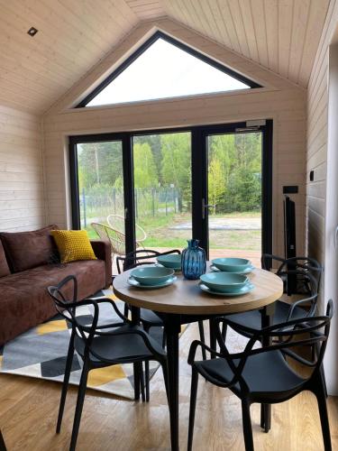 a table and chairs in a living room with a window at Przytulne Kątno in Kątno