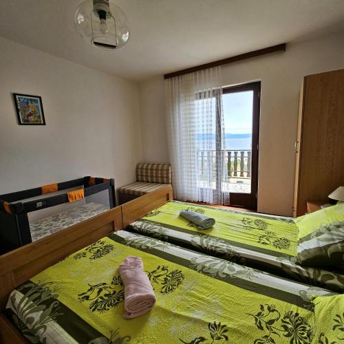 a bedroom with two twin beds and a window at Apartman Agava in Njivice