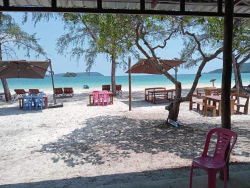 a group of tables and chairs on the beach at JIJI KOH RONG in Koh Rong