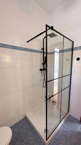 a glass shower in a bathroom with a toilet at Troglorent - Maison Troglodyte in Terque