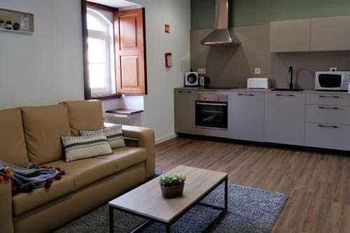 een woonkamer met een bank en een tafel bij O Cantinho do Colégio - Dourocollege in Lamego
