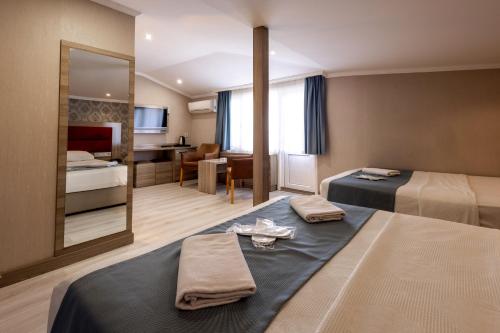 a hotel room with two beds and a mirror at Mora Hotel in Trabzon