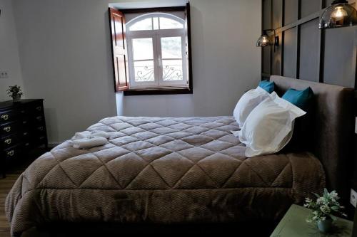 1 dormitorio con 1 cama grande y ventana en O Cantinho do Colégio - Dourocollege, en Lamego