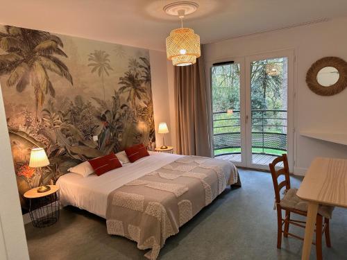 een slaapkamer met een groot bed en een groot raam bij Le Manoir d'Alexandre in Silfiac