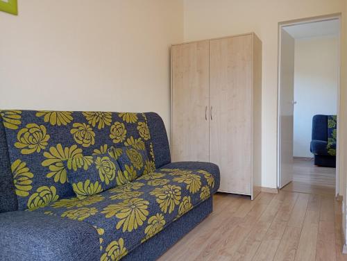 a living room with a blue couch and a cabinet at Ośrodek Wypoczynkowy Zapalenica in Szczyrk
