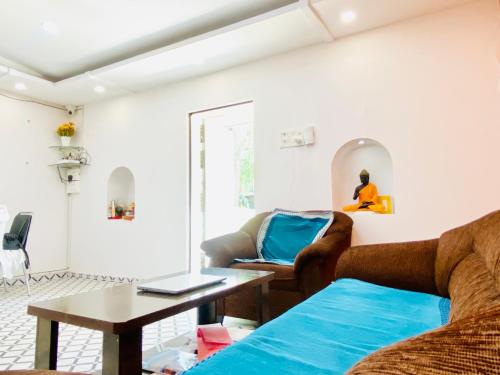 un soggiorno con divano e tavolo di Budget Private Ac Room with Kitchen Near Osho Garden a Pune