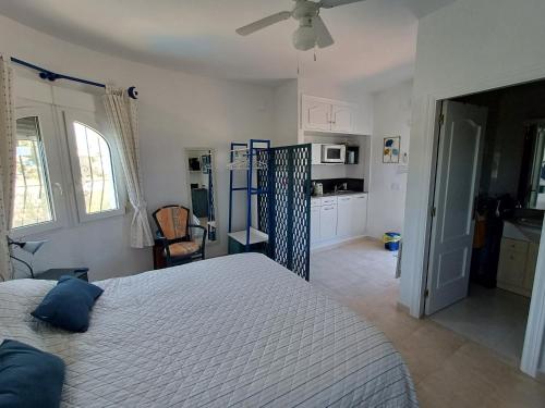 a bedroom with a large bed and a kitchen at Coquet studio indépendant in Els Poblets