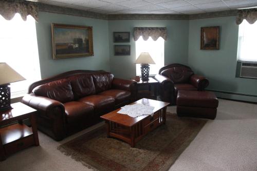 a living room with leather couches and a coffee table at The Winter Inn in Greenville