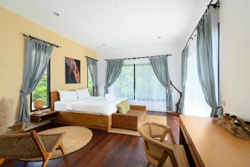 a bedroom with a bed and a desk at The Orange Villa Near Beach 海灘附近的家庭別墅 in Kamala Beach