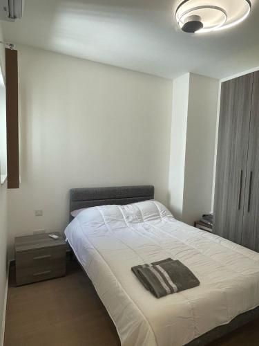 um quarto com uma cama branca e uma cabeceira preta em Three bedroom penthouse (Privilege Suite) em San Ġwann