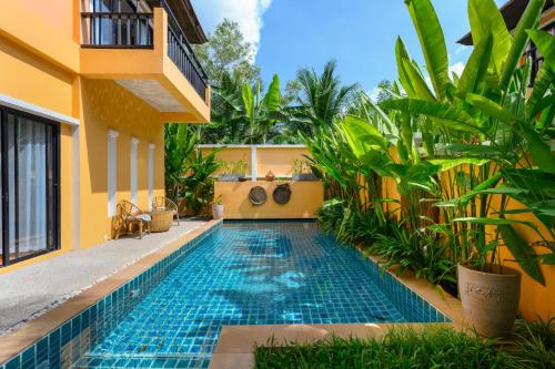 a swimming pool in the courtyard of a villa at The Orange Villa Near Beach 時尚家庭別墅提供免費接送服務 in Kamala Beach