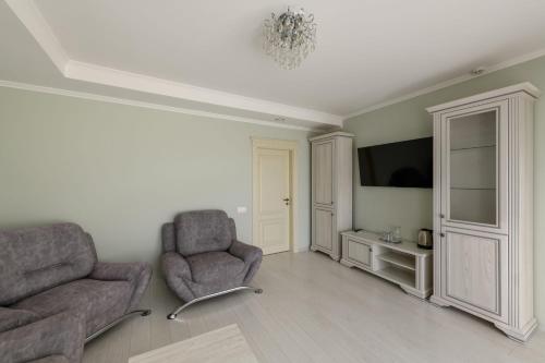 a living room with two chairs and a tv at Sagora Hotel in Chernivtsi